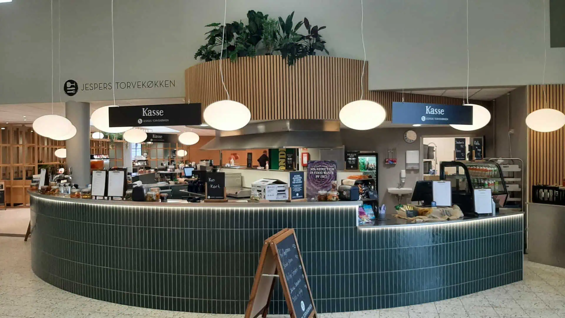 Bordopdækning til fest i Hal 1. Service med blå servietter, hvide stearinlys og blomster buketter til pyntning.